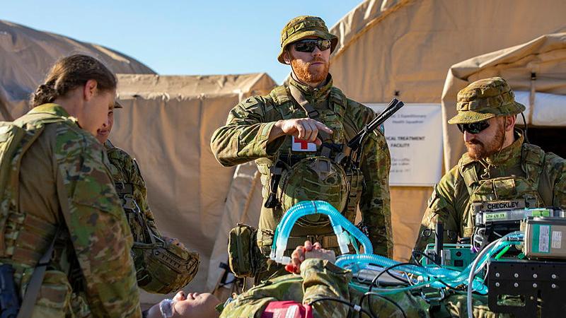 Personnel directs patient to the transport wagon.