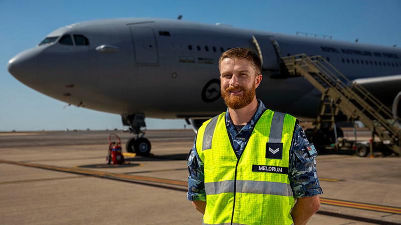 Corporal Meldrum standing in front of a plane