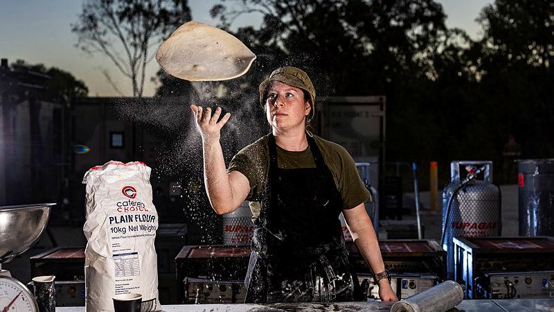 Australian Army cook Corporal Samantha Kenafake from the 10th Force Support Unit prepares pizza for soldiers at Camp Growl Shoalwater Bay Training Area.