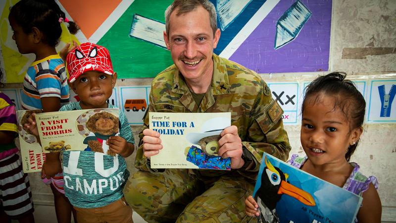 Australian Army officer Chaplain Cameron West visits Lofeagai Pre-school and introduces the children to Able Seaman Pepper Penguin and Sapper Pat from the ADF children’s book series.