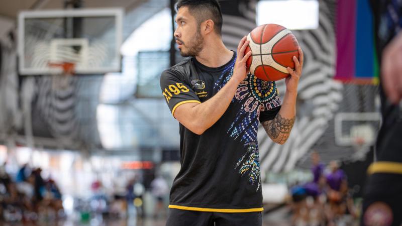 Leading Seaman Manuel Salas prepares to throw a ball during a basketball game.