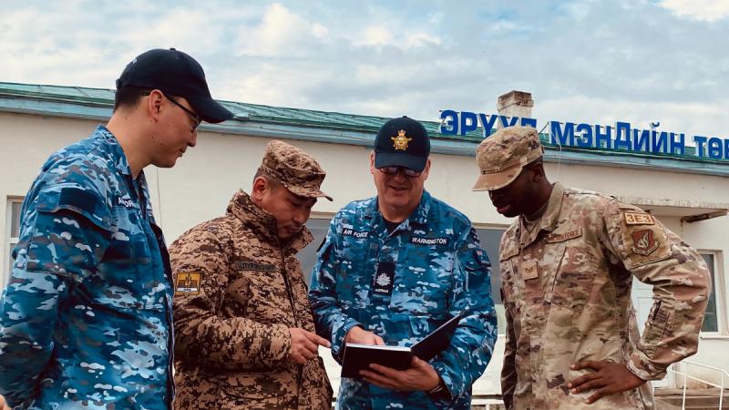 Royal Australian Air Force engineer and interpreter Flight Lieutenant Burentogtokh Altantsetseg (Left), Mongolian Armed Forces Lieutenant Tsendendamba (Centre Left), Royal Australian Air Force engineer Warrant Officer Andrew Warmington (Centre Right) and United States Pacific Air Force Staff Sergeant Reginald Madison discuss renovation planning at the Tsenser community hospital.