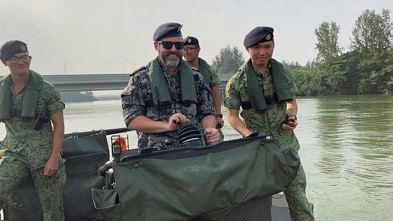 Lieutenant Commander Michael Booth operating a Singapore Armed Forces boat.
