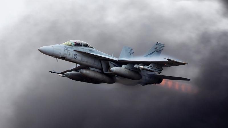 A RAAF Super Hornet flies in a cloudy sky