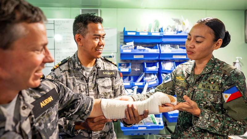  Medical Officer Lieutenant Phil Salinas watches as Philippine Marine Corps Sergeant Geraldine Corbita applies a plaster splint to Medical Officer Phil Aubin on board HMAS Canberra during Exercise Alon. 