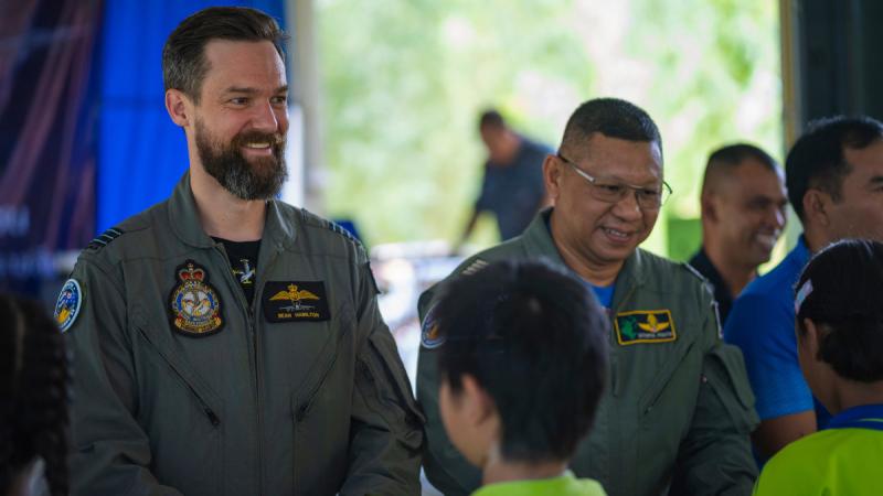 Commanding Officer 1 Squadron Wing Commander Sean Hamilton and Royal Thai Air Force Group Captain Sithipol Pomtri pass gifts to students from Nong Sao Diao school during Exercise Thai Boomerang.
