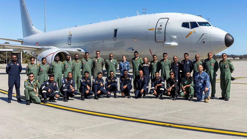 The Indian Navy P-8I Neptune crew with RAAF personnel on the tarmac with An Indian Navy P-8I Neptune behind them.