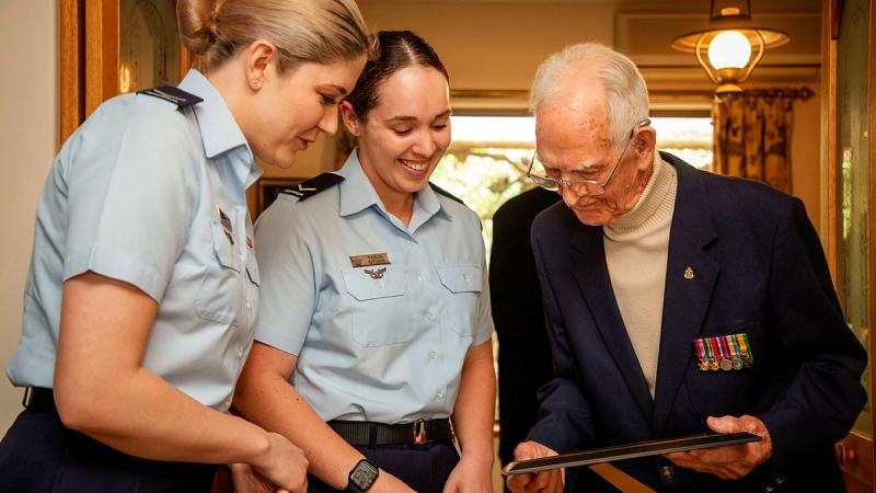Leading Aircraftwomen Erica Moy and Tahlia Kitchin, from 83 Squadron, and Mr Lyall Ellers reflect on his Air Force service during his 100th Birthday celebrations held at his home in Seacliff, Adelaide, SA. Photos: Sergeant Nicci Freeman