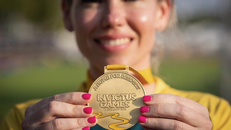 Karney Armstrong holding gold medal 