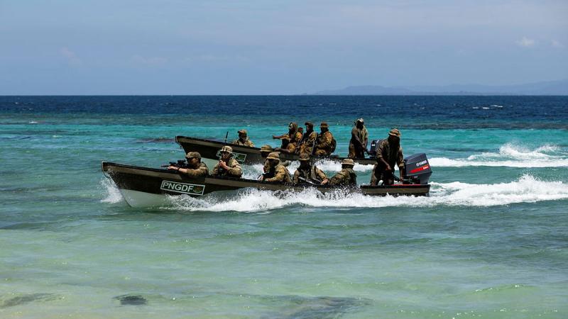 Soldiers arrive onshore in boats. 