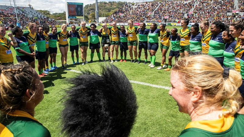 Members of the woman’s ADF Rugby League team form a huddle with the PNGDF Rugby League team.