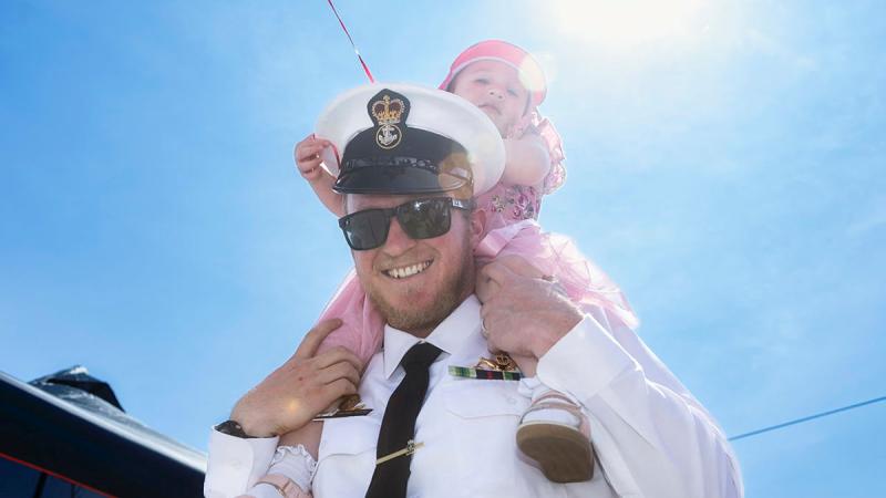 Petty Officer Electronic Warfare Roland Brew with his daughter at the Members and Family Day in HMAS Watson, NSW.