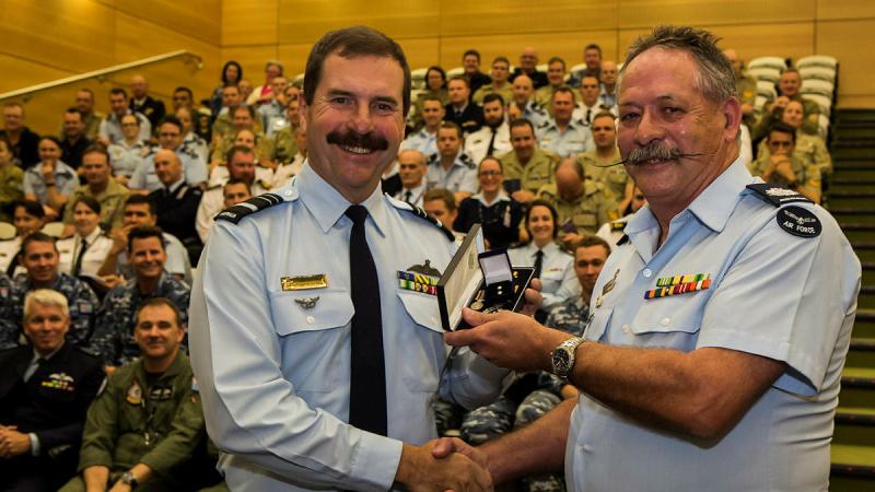 Chief of Air Force Air Marshal Leo Davies presents Warrant Officer Wayne Newman with his second clasp to the Federation Star for 45 years service in the RAAF. 