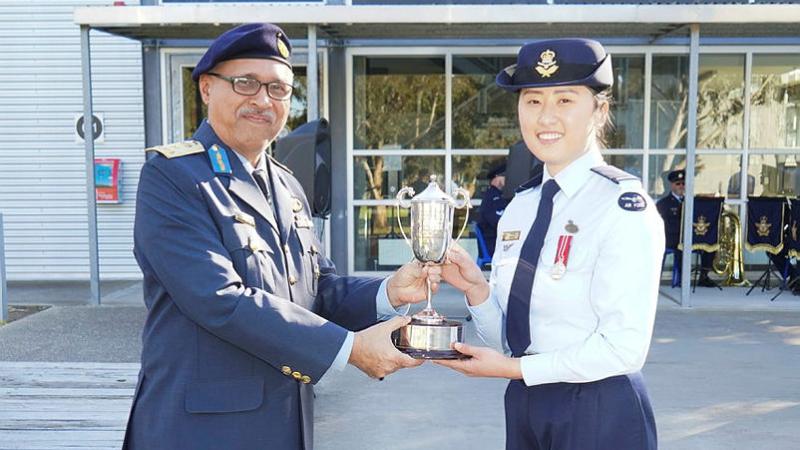 RMAF Brigadier Ben Khedda presents a trophy to Pilot Officer Pearl Jeong.