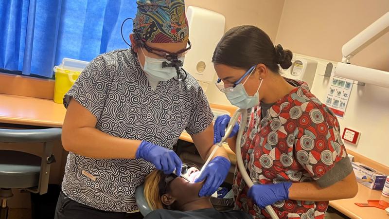 Dental Officer Flight Lieutenant Alexis Dieu (L) and dental assistant Leading Aircraftwoman Ocean Mitchell (R) from 2 Expeditionary Health Squadron treat a patient at Wadeye, Northern Territory, during a remote NT Health dental visit.