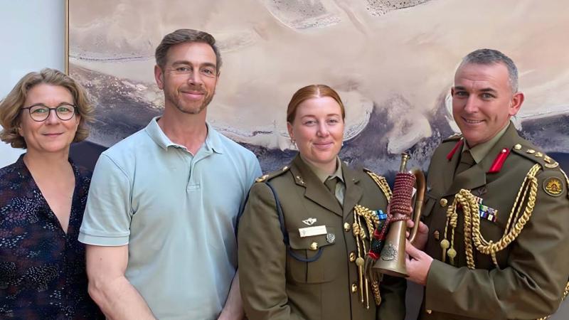 Katia Hoffmann, Luke Giacomin, Australian Army officers Major Jess Ward, Assistant Defence Attaché in Berlin and Colonel Paul Graham, Australian Defence Attaché, at the Australian Embassy in Berlin, with one of a growing collection of fake vintage Western Australian University Regiment bugles.