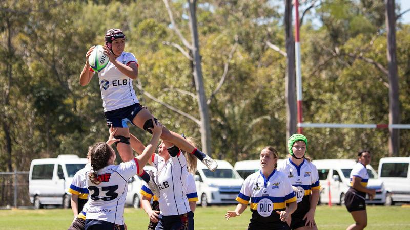 Corporal Yolanda Forsyth receives the ball as she is lifted up by her team. 