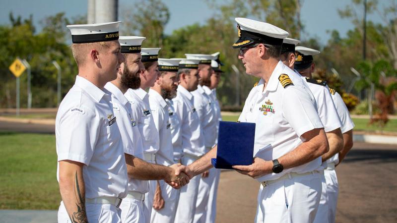 Captain Simon Cannell presents a challenge coin to Leading Seaman Grady Munks during a homeporting ceremony at Larrakeyah Defence Precinct, Darwin, NT.