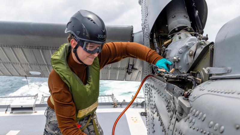 Navy aviation technician Able Seaman Casey Anderson from HMAS Toowoomba takes oil samples from the embarked MH-60R helicopter Valkyrie during a regional presence deployment.