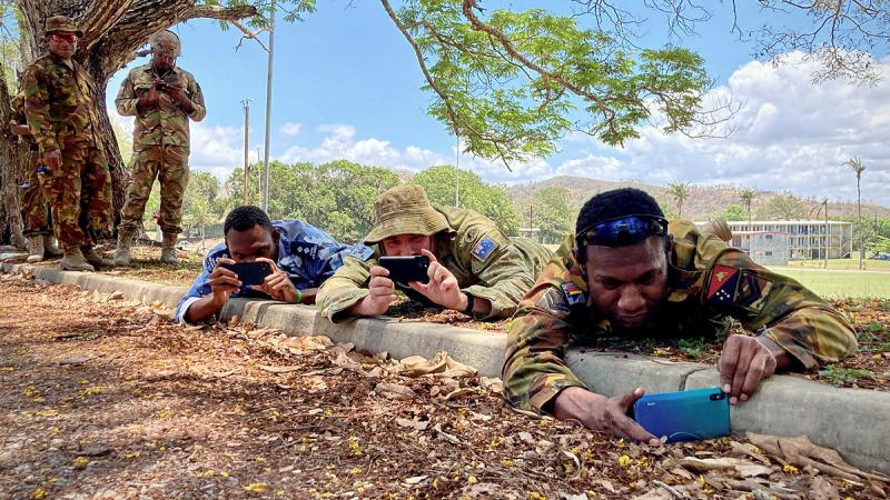 PNGDF Corporal Emmanuel Haro and Lieutenant Heydan Chan, with Australian Army Officer Major Taylor Lynch, practicing photo composition.