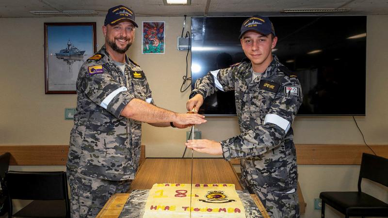 Commanding Officer HMAS Toowoomba Commander Darin MacDonald, left, and youngest crewmember, Seaman Jack Lefevre, cut Toowoomba’s 18th birthday cake during a regional presence deployment. Photo: Leading Seaman Ernesto Sanchez