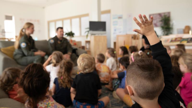 A McGraths Hill Learning Centre student raises his hand to ask questions during a visit from No 37 Squadron members, Flight Lieutenant Brendan Smith and Corporal Natashia Jorgensen.
