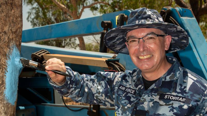 Officer Commanding Health Services Wing, Group Captain Glen Storrar, helps paint a tree in support of the Blue Tree Project at a BBQ promoting mental health in Derby in Western Australia.