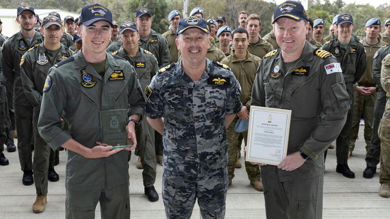 Commander Fleet Aviation Arm Commodore David Frost presents the 2022 McNichol Trophy to Seaman* Aircrewman Joshua Williams (left) and Commanding Officer 723 Squadron Commander Samuel Dale.