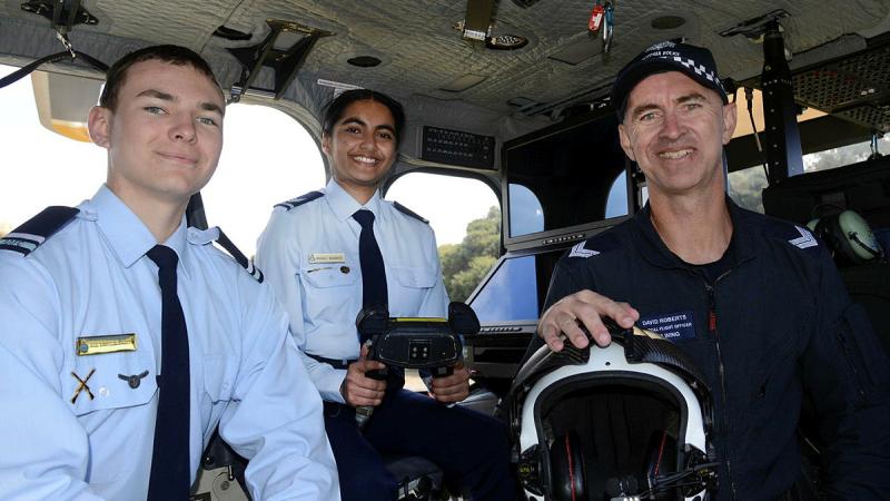 Cadet Under Officer Ace Simpson-Braden (left) and Cadet Sergeant Monali Kharade are shown some of the finer details of a Victoria Police Air Wing aircraft by Senior Constable David Roberts.