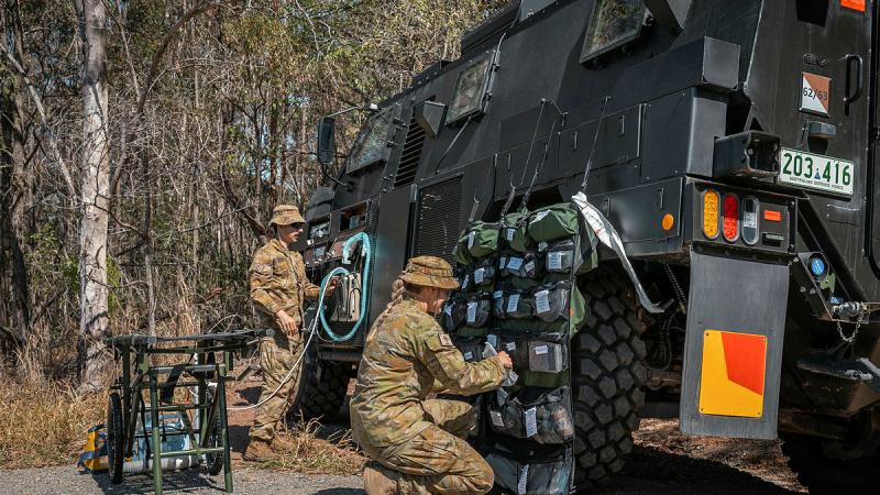 Australian Army personnel preparing the electric protected mobility vehicle for a capability test.