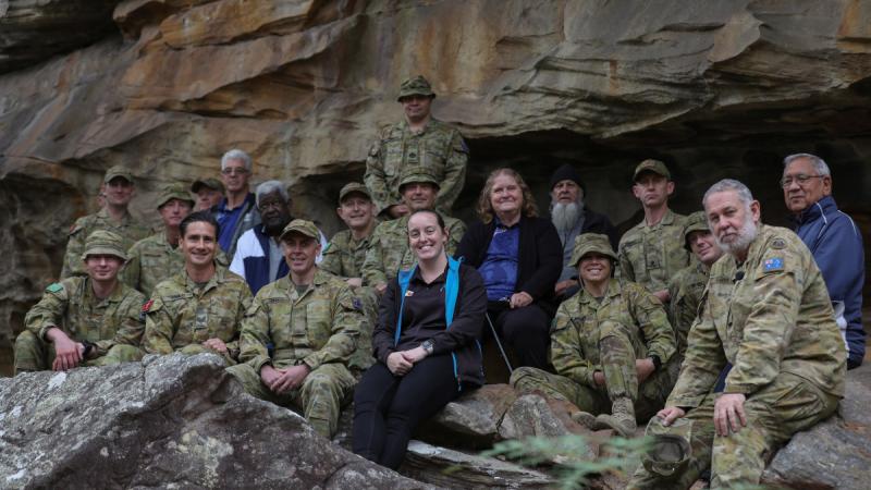 Members of 2 (Australian) Division with local Indigenous Elders in front of Indigenous rock paintings at Cubbitch Barta National Estate area. 
