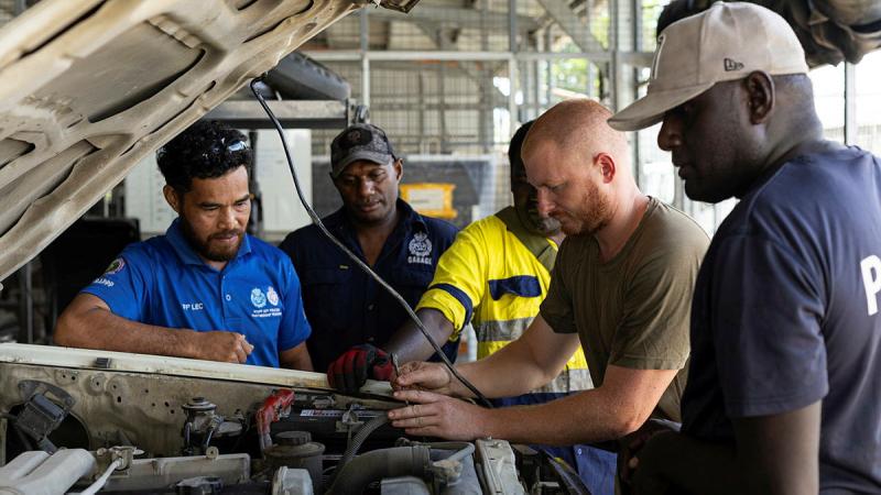 Craftsman Bradley Scheef and members from the RSIPF maintain a police vehicle.