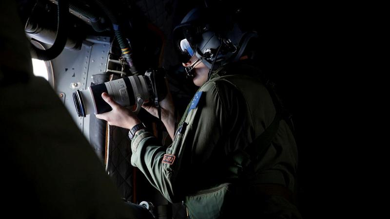 Loadmaster Corporal Mitchell Hordern of 35 Squadron photographs vessels out of a C-27J Spartan during Operation Solania. 