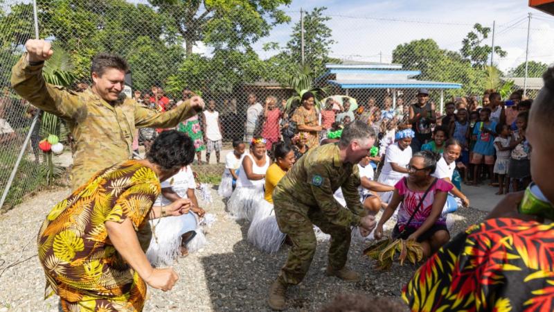 Australian Army officer Major Roger Brennan and Royal Australian Navy officer Lieutenant John Townsend dance with local community members and nurses at the one year anniversary celebrations of the opening of Burns Creek Medical Clinic in Honiara, Solomon Islands.