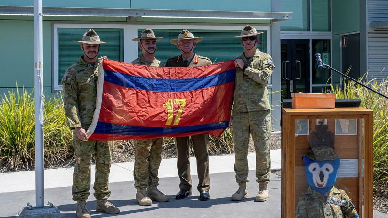 From left, Officer Commanding 17 Construction Squadron Major Lincoln Barbare, flag orderly Sapper Jack Miles, Major General Stephen Day and Squadron Sergeant Major 17 Construction Squadron Warrant Officer Class 2 Taj Whelan with the returned flag at RAAF Base Amberley. 