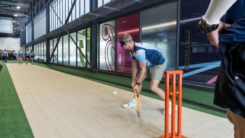 RAAF cricket players practice hitting the ball wearing vision-impairment glasses to simulate playing blind cricket.
