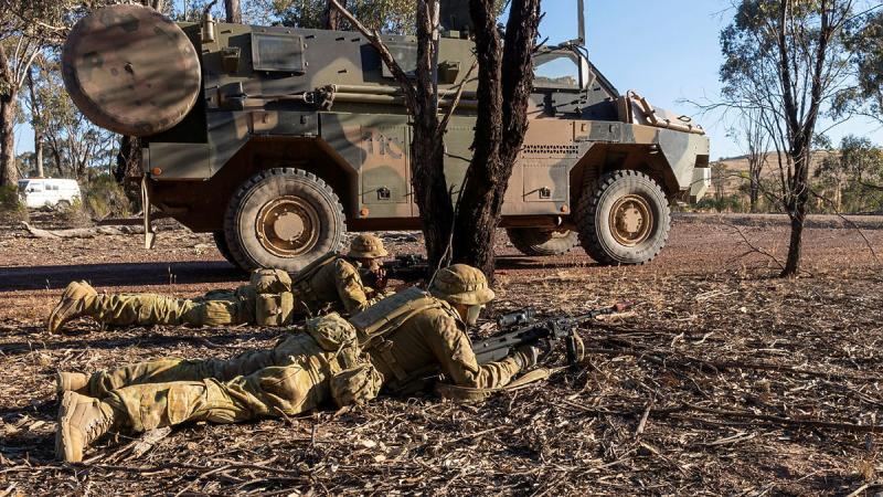  Soldiers provide security next to a Bushmaster Protected Mobility Vehicle during Exercise Rhoden Strike at Puckapunyal Military Area. 