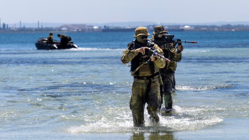 Australian Army and Indian Army soldiers manoeuvre from Zodiac watercraft on to a beach at Garden Island in Western Australia as part of a training activity during Exercise Austrahind 2023.