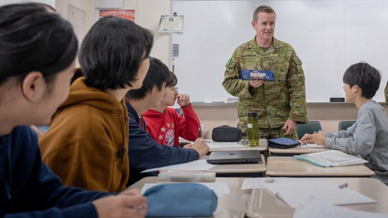 Australian Army soldier Sergeant Richard Maconochie delivers some 'Tim Tam diplomacy' during a visit to Hokkaido International School, Sapporo, Japan, during Exercise Yama Sakura 85.