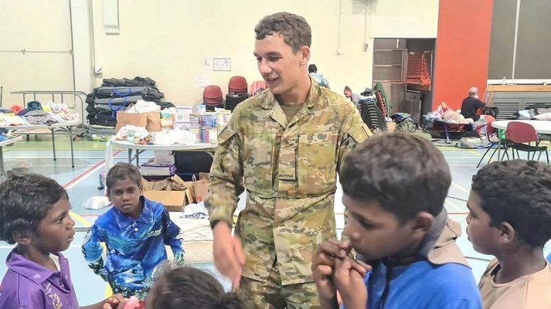 Children from the Wujal Wujal community at the PCYC in Cooktown talk about their experiences during Tropical Cyclone Jasper with Private Ronin Saunders, of the 51st Battalion, Far North Queensland Regiment.