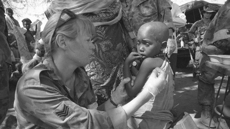 Australian Army Medic, then Sergeant Joanne Cook, examines a little girl with malaria in February 1993.