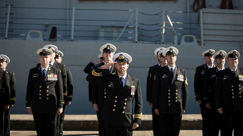 Lieutenant Commander Nick Graney salutes during the national anthem as part of HMAS Newcastle’s decommissioning ceremony at Fleet Base East, Sydney in 2019.