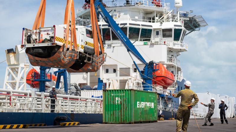 Australian Defence Vessel Reliant crew members prepare to lower a donated firetruck onto Betio Port, Kiribati.