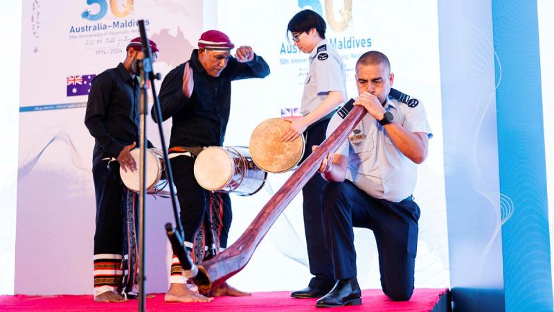 Traditional Bodu Beru drummers, including RAAF Band drummer Corporal Naomi Tan, accompany RAAF didgeridoo player Flight Lieutenant James Evans.