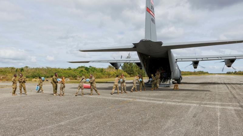 RAAF and United States Air Force personnel unload cargo from a USAF C-130J aircraft at Tinian North airfield during Exercise Cope North.