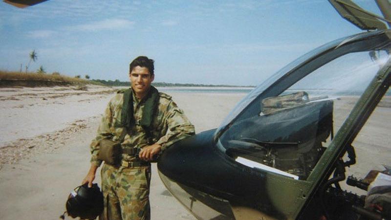 Former Army and Air Force pilot and runner up on series one of Alone Australia Mike Atkinson stands next to a Kiowa helicopter on a remote beach on the Northern Territory west coast in 2002. 