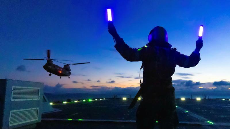 Leading Seaman Michael Mason marshals an Army CH-47 Chinook on board HMAS Choules during aviation training off the coast of Townsville, QLD.