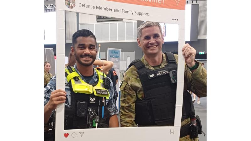 Defence members hold a 'Hello from Townsville' frame up at the 2024 welcome event in Townsville, Queensland.