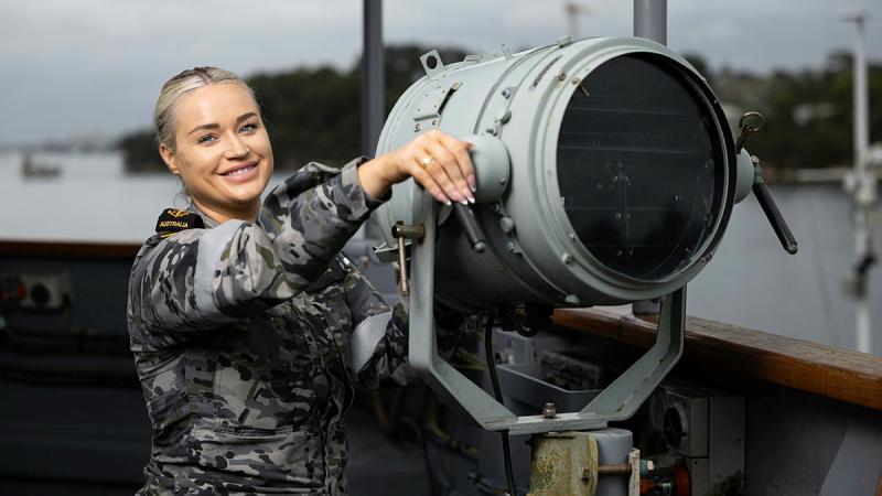 Leading Seaman Chloe Hearne with a 10-inch light on the bridgewing of HMAS Yarra. 