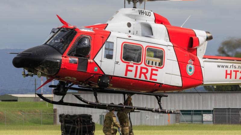 Army soldiers prepare cargo for an airlift by the Rural Fire Service helicopter.